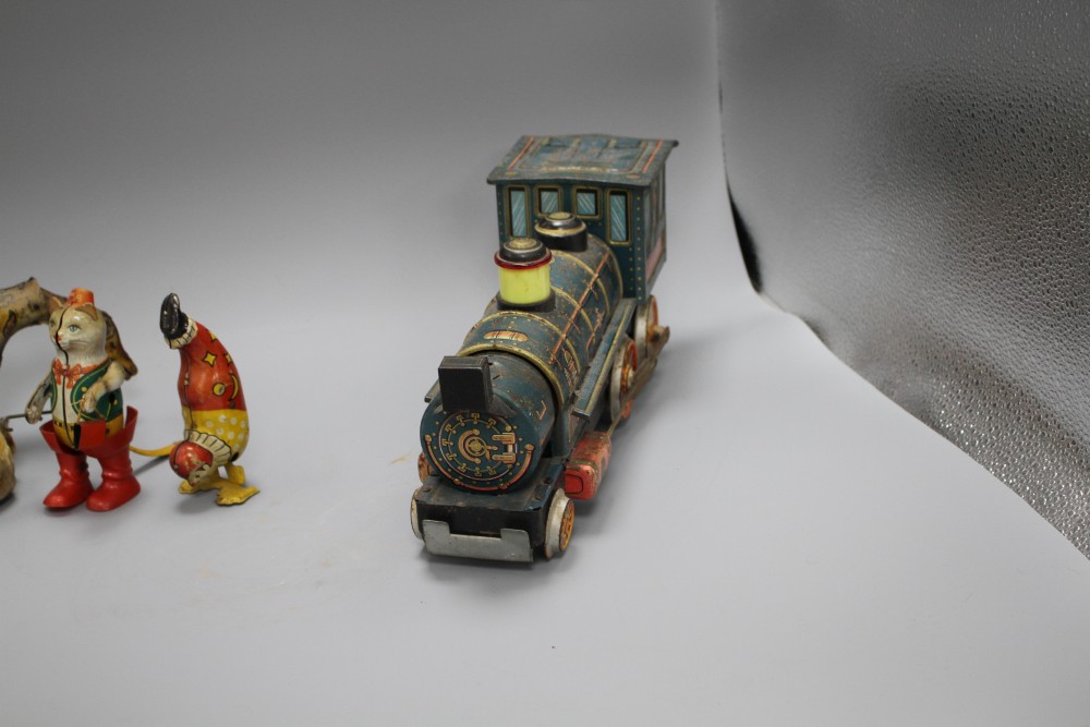 A clockwork cat and ball, and four assorted tinplate toys